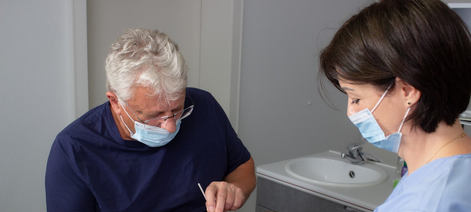Zahnarzt Dr. Reinhard Fuchs und seine Assistentin während einer Behandlung